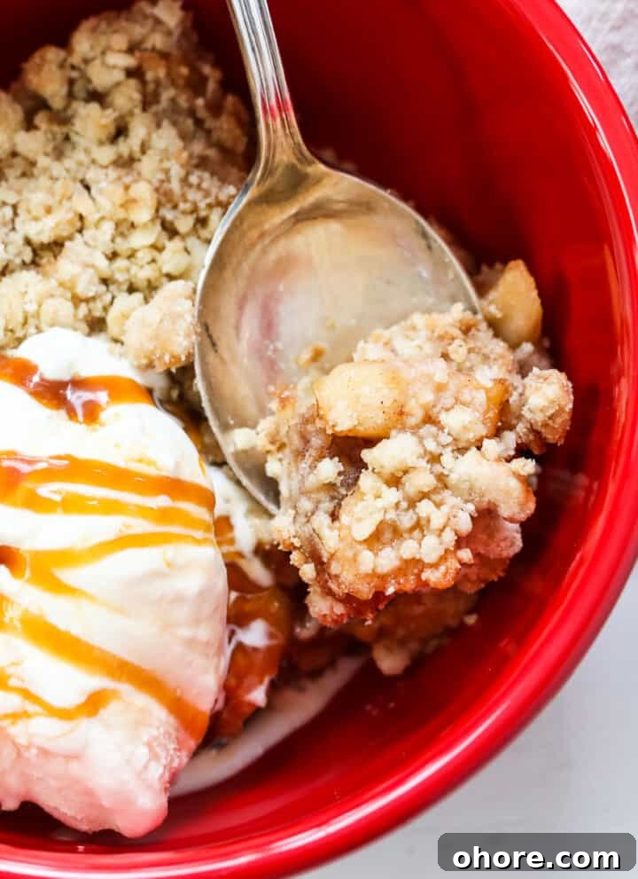 Apple Crisp in a red bowl with ice cream.