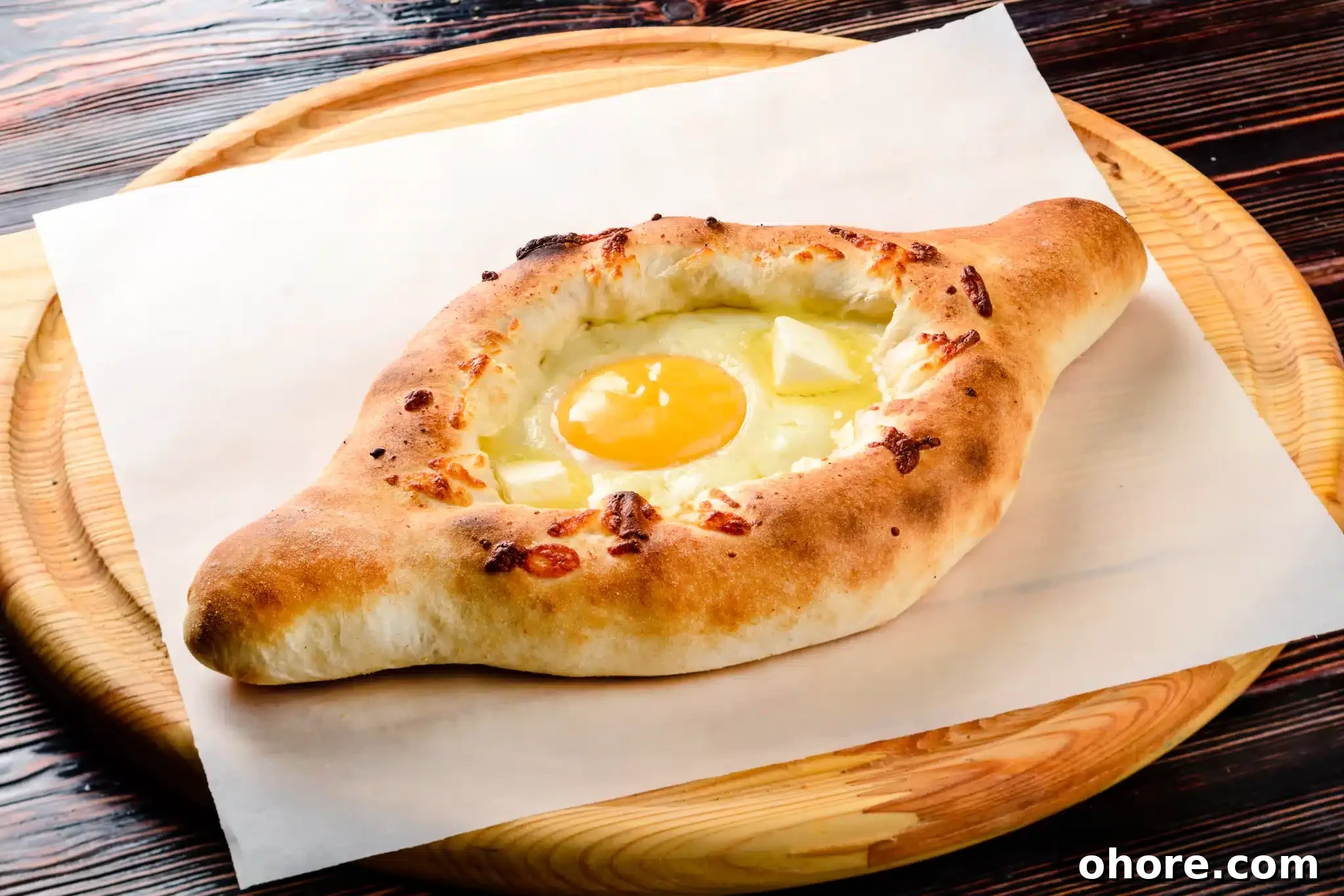 A cutting board displaying a mouthwatering khachapuri.