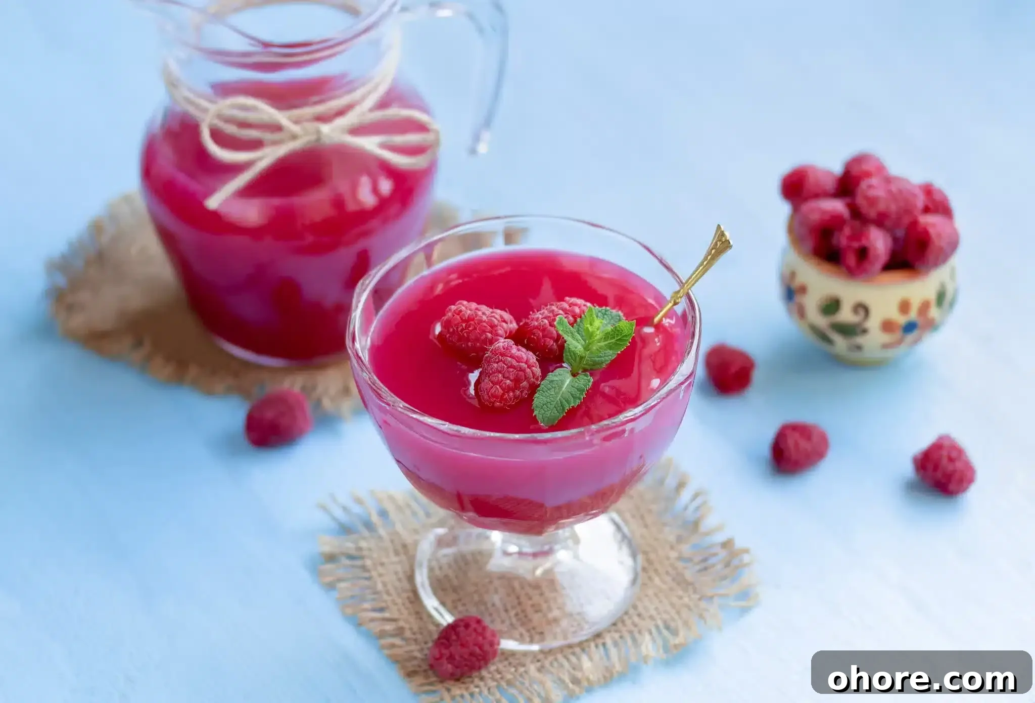 Kissel served in a cup and garnished with raspberries and mint.