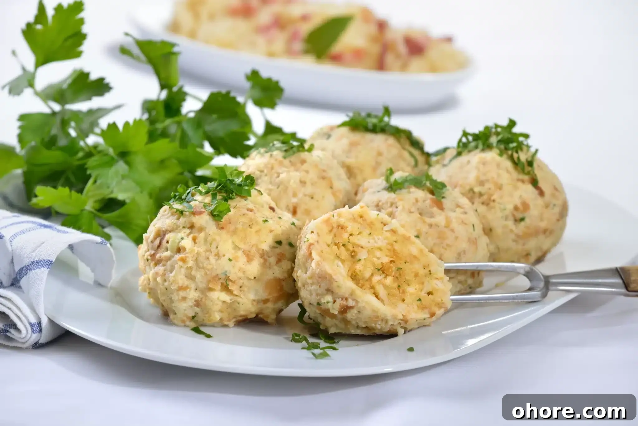 A close-up of a portion of knödel garnished with parsley.