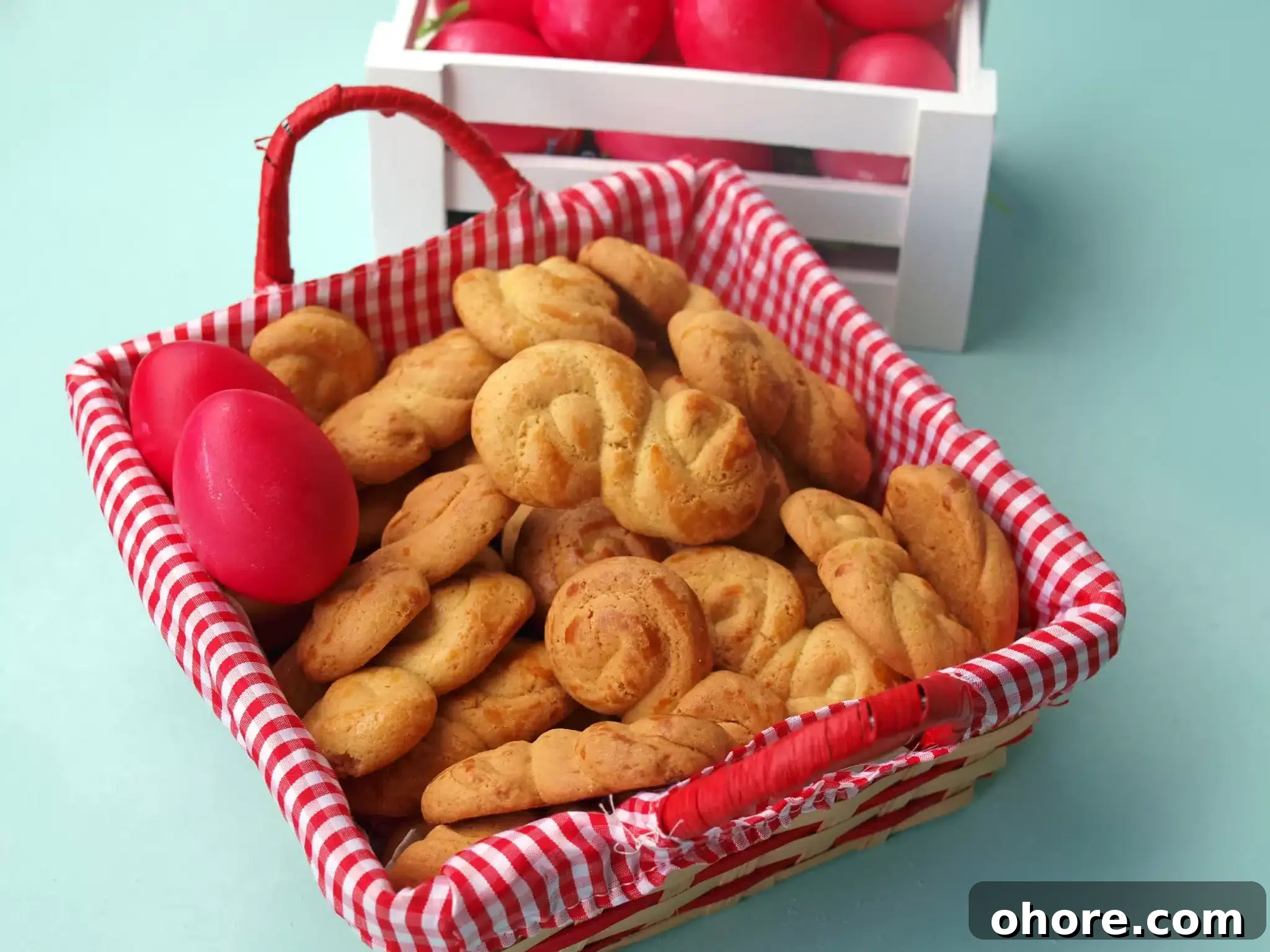 A basket full of koulourakias and some red eastern eggs nearby.