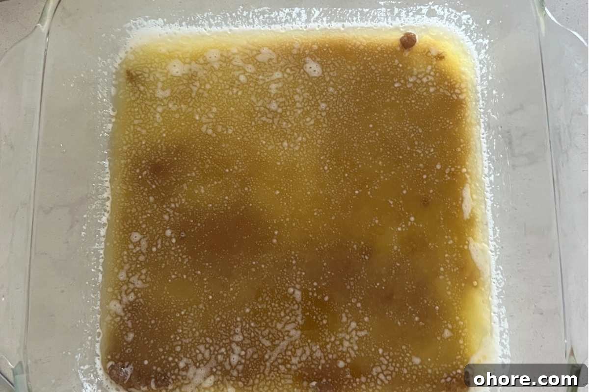 Trisha Yearwood’s Classic Pineapple Upside-Down Cake Recipe 3 Butter and brown sugar melted in a glass baking dish.