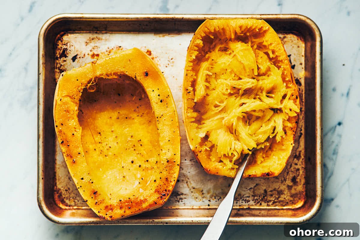 How to Cook Spaghetti Squash: Simple Oven and Microwave Methods 5 Spaghetti squash cut in half lengthwise and cooked on a metal baking sheet with noodles scooped out
