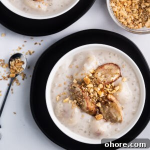 Two bowls of che chuoi topped with crushed peanuts and sesame seeds.