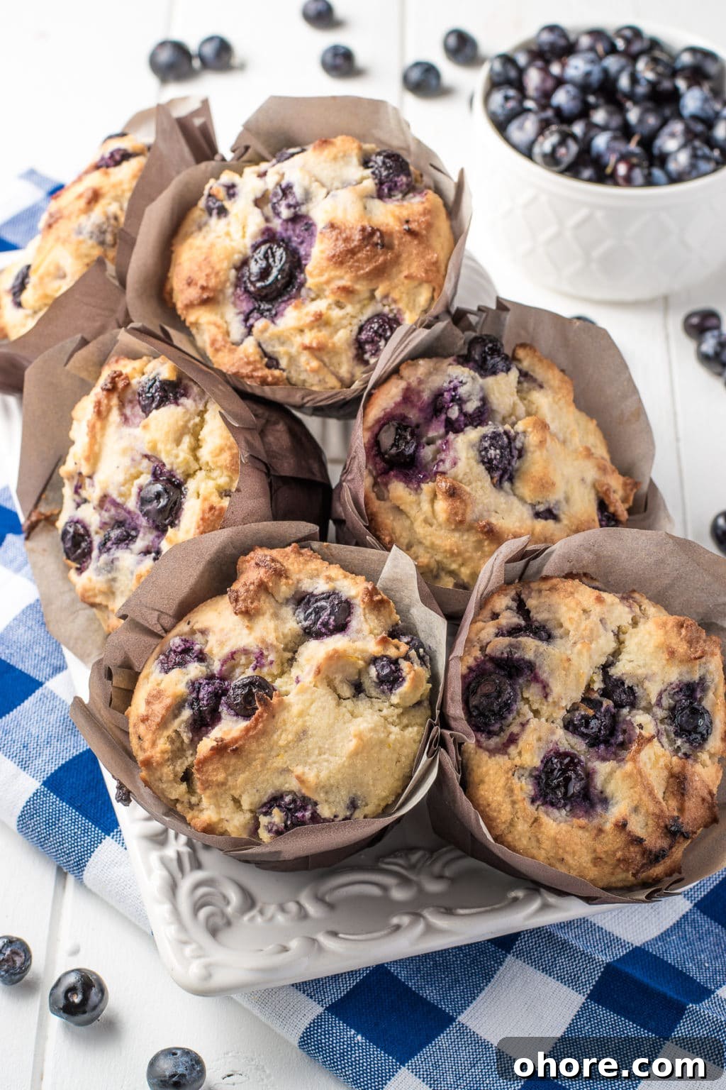 Keto blueberry muffins with a fluffy texture in brown muffin wrappers. The image is intended to show an example a low-carb and gluten-free breakfast idea perfect for busy mornings.