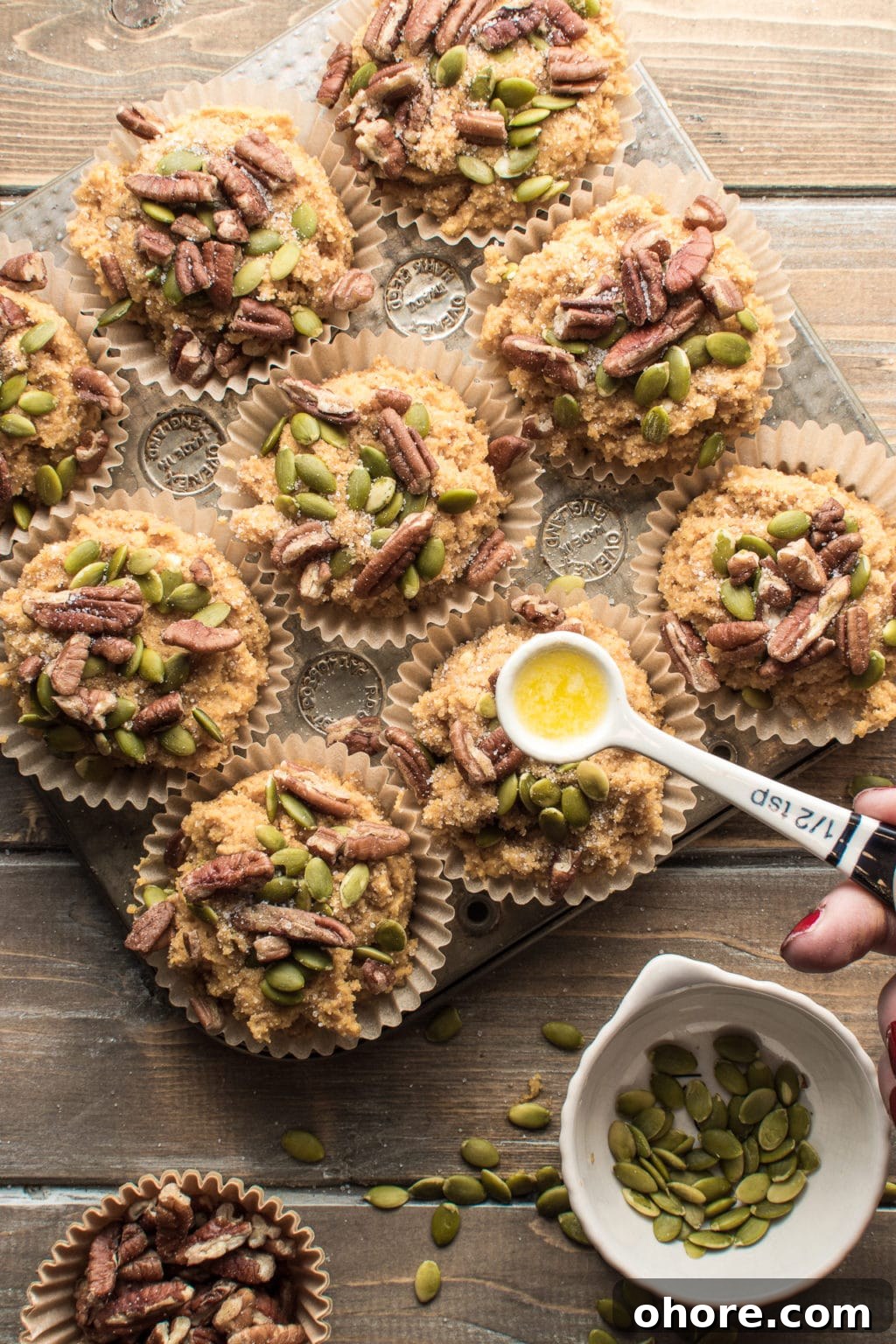 Low-carb pumpkin spice muffins topped with pecans and pumpkin seeds. The image intended to show an example of keto muffin recipes you can make on a carb restricted diet. 