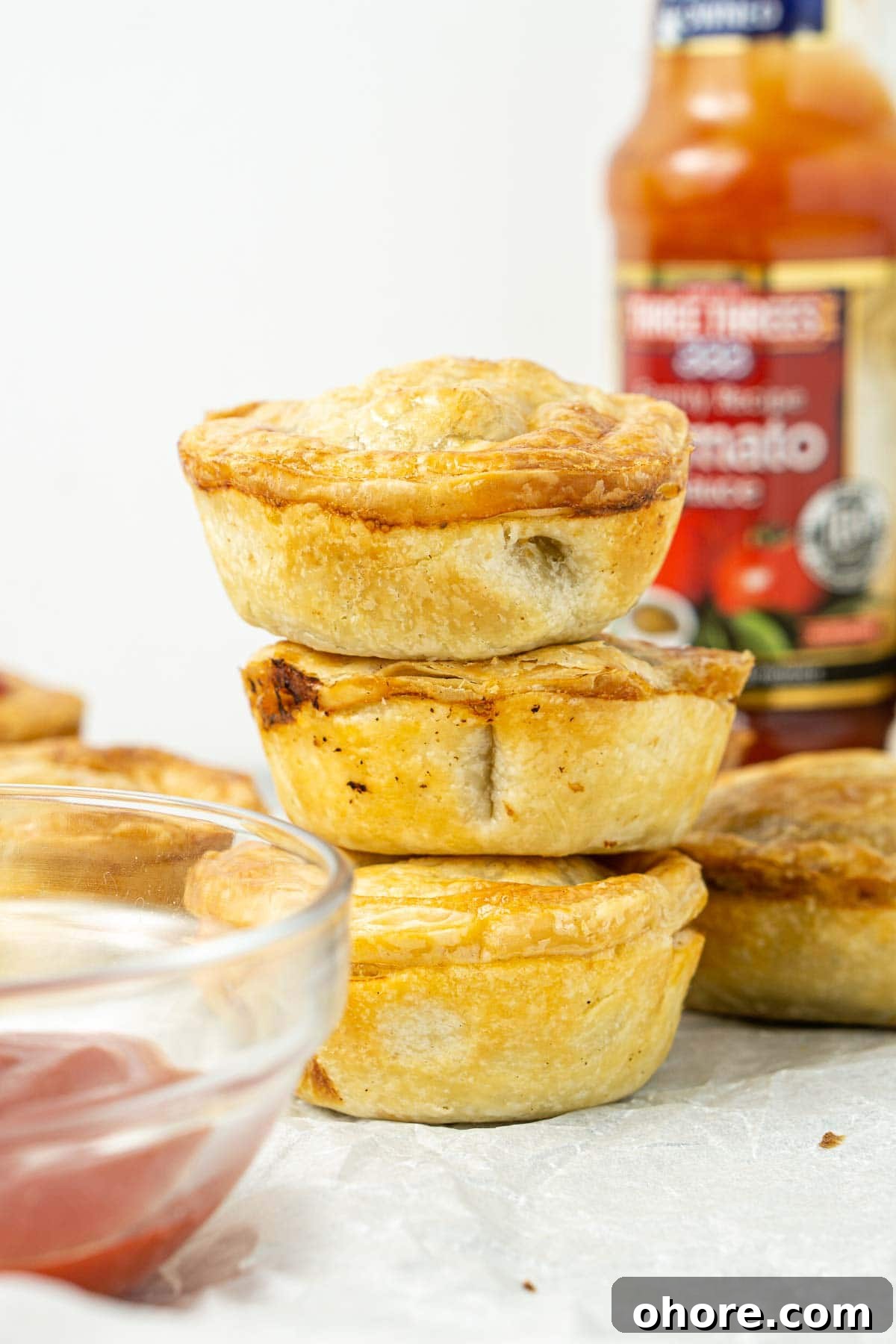 Three mini beef pies stacked on top of each other.