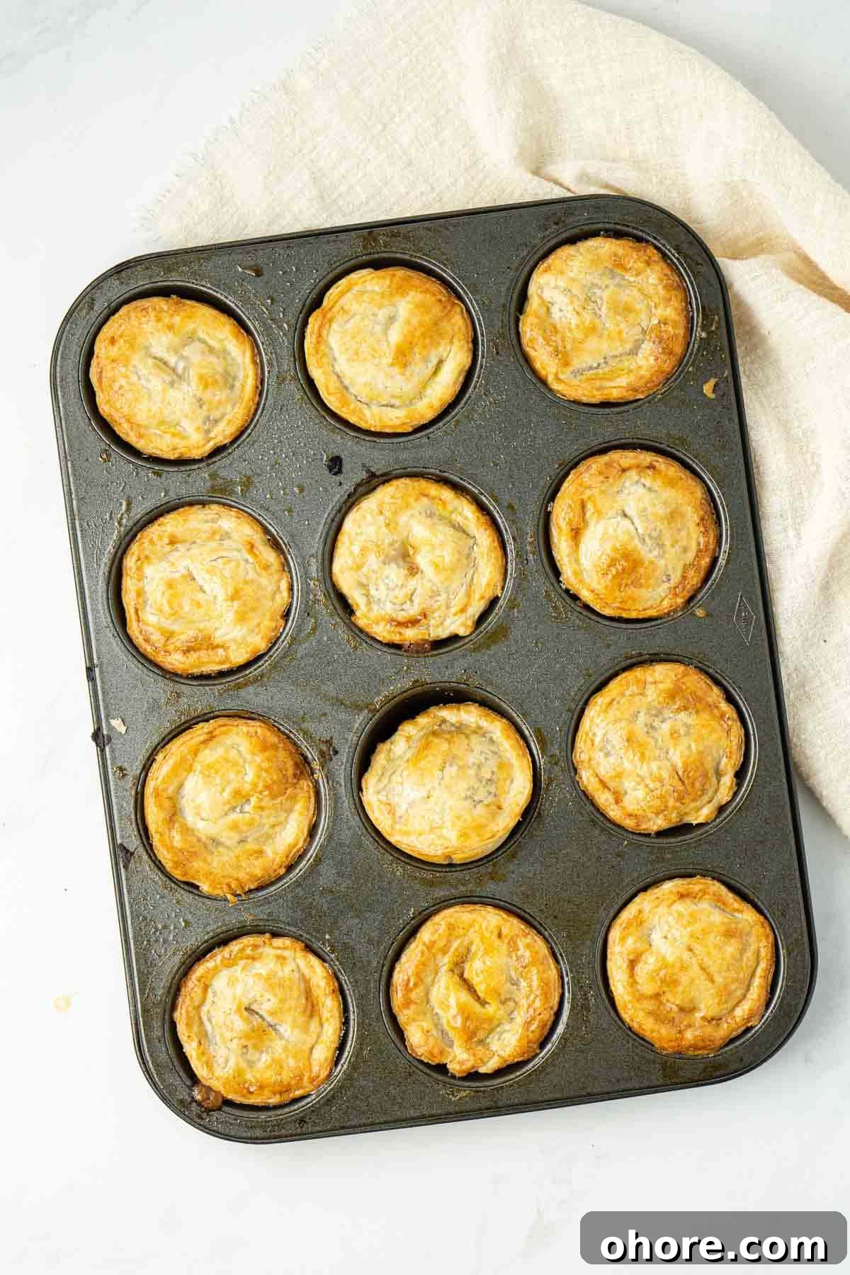 Cooked pies in a muffin pan, fresh from the oven.