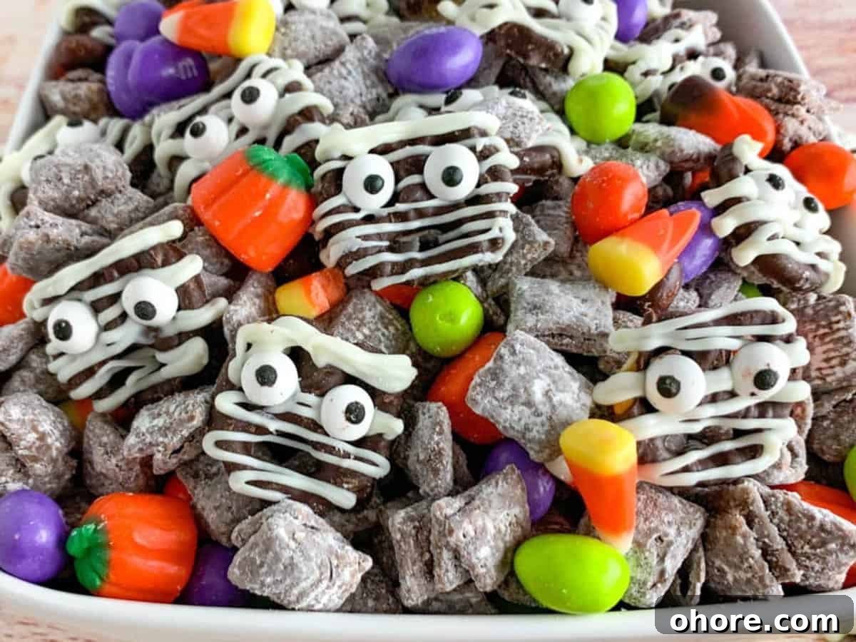 Kid-Friendly Halloween Snack Ideas for Kids 5 Up close photo of Halloween snack mix with Mummy decorated pretzels, Halloween M&Ms, and candy corn.