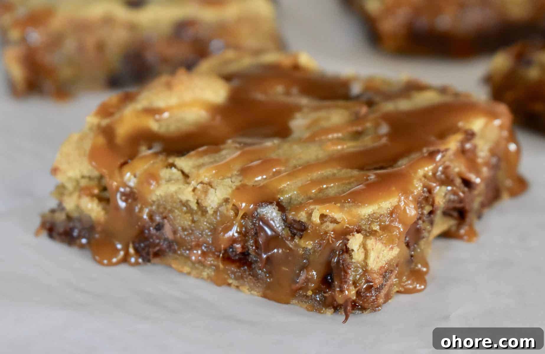Milky Way Blondies with Caramel and Chocolate Delight 3 Milky Way Blondie with caramel drizzled overtop.
