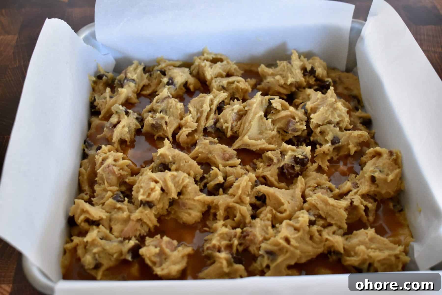 Milky Way Blondies with Caramel and Chocolate Delight 9 spoons of batter over the caramel sauce.