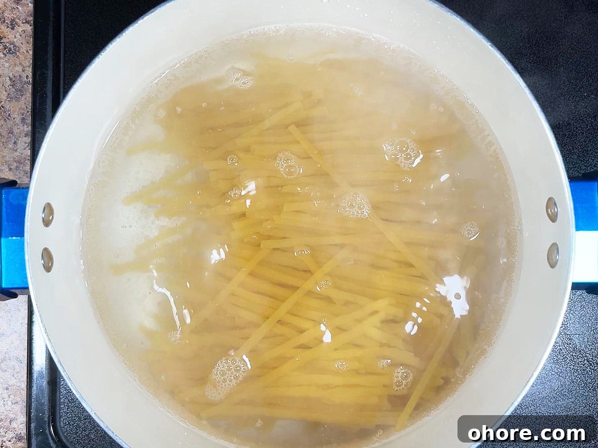 Creamy Marry Me Chicken Pasta Recipe for Weeknight Dinner 4 Cooking the fettuccine noodles in salted water.