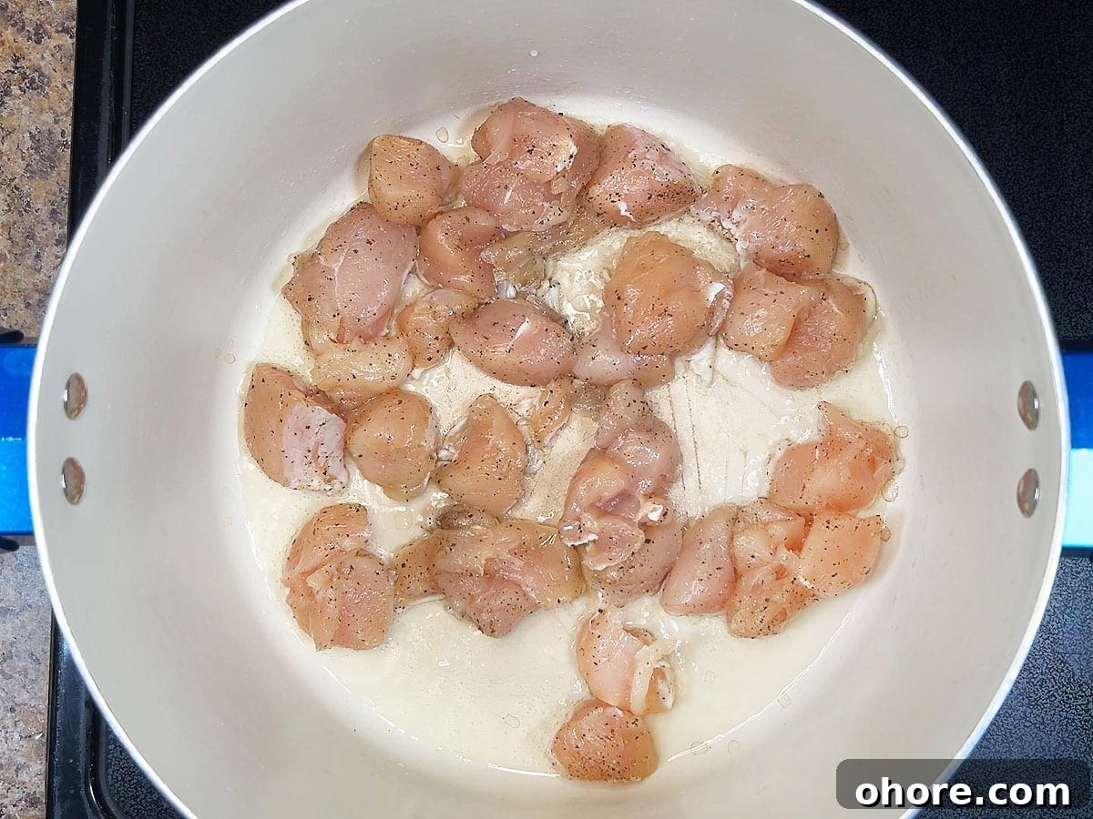 Creamy Marry Me Chicken Pasta Recipe for Weeknight Dinner 5 Seasoned chicken breasts cooking in hot oil in a large pot.