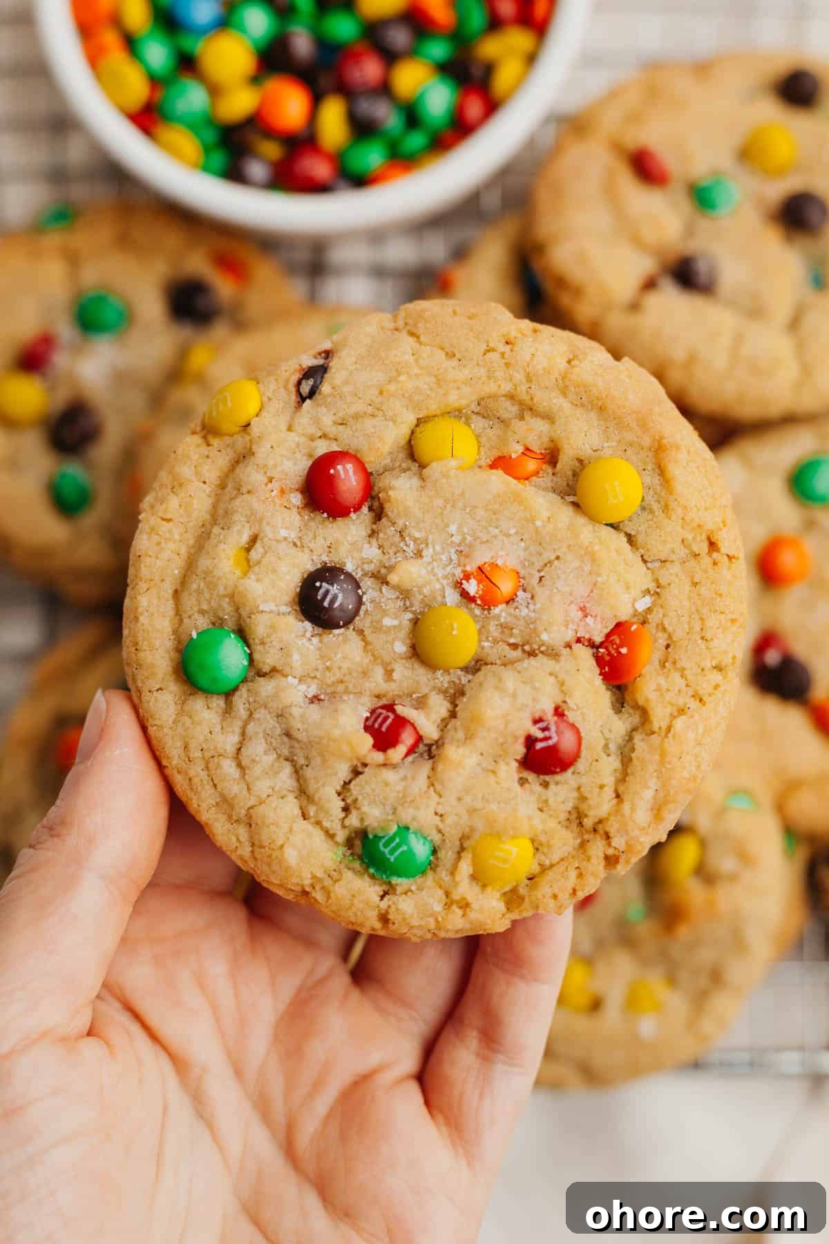 Soft Chewy Mini M&M Cookies — Small Batch Recipe 2 A hand holding a mini m&m cookie.