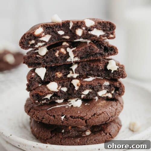 A stack of inside out chocolate chip cookies broken in half, showing the fudgy inside.