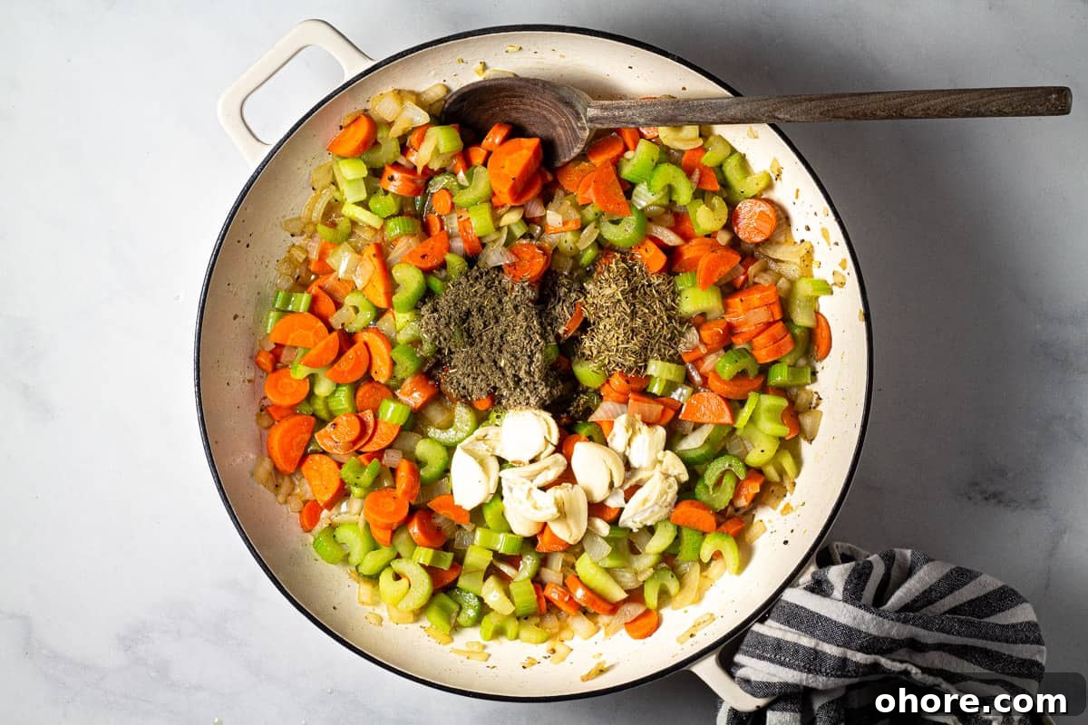 Large pot filled with carrots celery onion herbs and garlic 