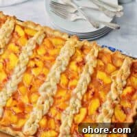 Rustic Peach Slab Pie Recipe for Serving a Crowd 8 Full sheet pan of peach slab pie with braided top crust