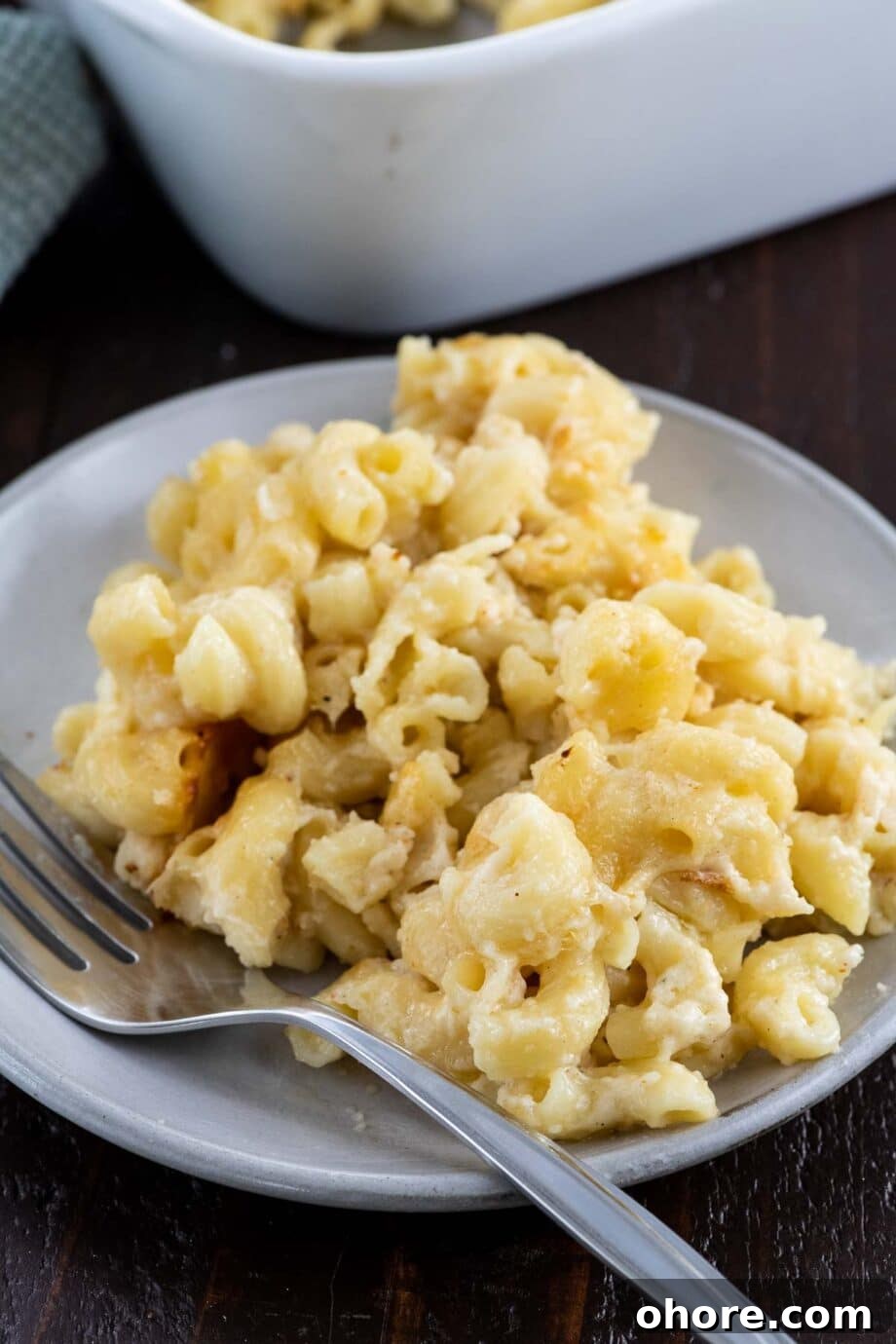 old fashioned baked macaroni and cheese on a plate with a fork and napkin