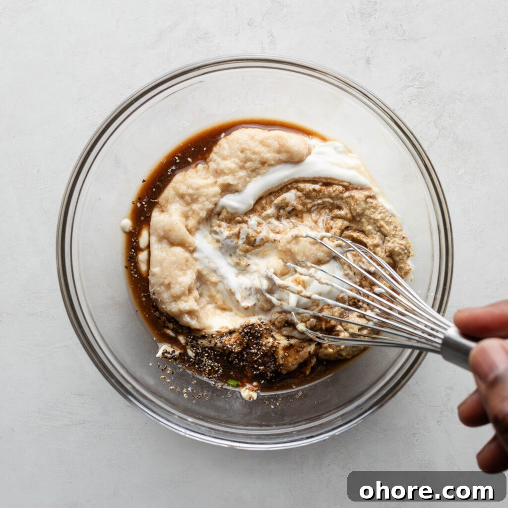 Creamy Horseradish Sauce for Prime Rib: Tangy Roast Beef Topping 4 Whisking horseradish prime rib sauce ingredients in a glass bowl.
