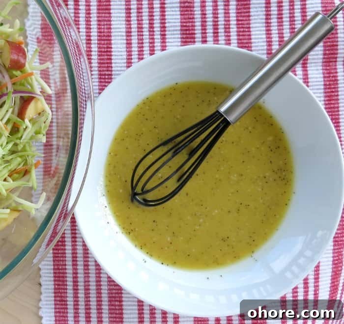 Quick Broccoli Slaw Recipe You Can Make Tonight 5 broccoli slaw dressing in a white bowl with a black whisk